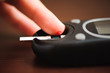 © nagaets - close up of male finger with blood drop and test stripe to checking blood sugar level by Glucose meter