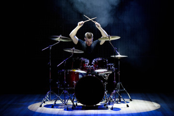 Drummer playing the drums with smoke and powder in the background