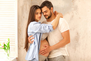 couple in love pregnant cuddling, waiting for baby