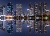 Fototapeta Nowy Jork - light from modern building bright in night city with skyline symmetric water mirror reflection. night cityscape concept.