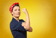 Self-confident Middle Aged Woman With A Clenched Fist Rolling Up Her Sleeve, Text Space, Tribute To American Icon Rosie Riveter