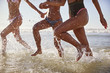 © Monkey Business - Close Up Of Women Running Through Waves On Beach Vacation