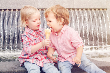 group portrait of two white caucasian cute adorable funny children toddlers sitting together sharing