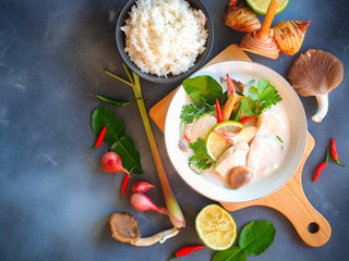 Wall Mural - Thai galangal chicken soup in coconut milk or Tom Kha Gai,famous traditional Thai food serve with jasmine steam rice in top view on gray background.