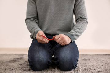 Wall Mural - Young Muslim man praying, indoors