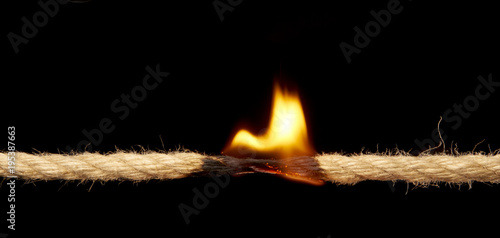 Flaming rope about to break. Isolated on black background. Studio Shoot. With copy space text.