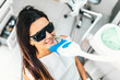© bedya - Teeth whitening in dental clinic for pretty female patient