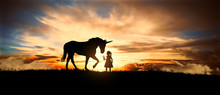 A Sweet Little Girl Offers Fresh Grass The Unicorn In A Meadow At Sunset