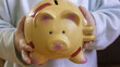 Financial education concept - saving money from a small one child, piggybank in a small hands
