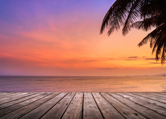 Wall Mural - Empty wooden terrace over tropical island beach with coconut palm at sunset or sunrise time