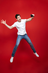 Wall Mural - Full length portrait of a happy young man in white t-shirt