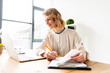 © Drobot Dean - Cheerful young business woman sitting in office