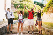 © dusanpetkovic1 - Joyful friends jumping with hands in the air on huge stairs of a fortress on a trip.