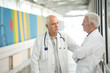 © auremar - two senior doctors talking in hospotal corridor