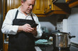 © karrastock - Man of 59 year old with smartphone in the kitchen of his house.