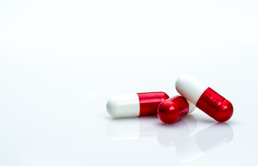 Poster - Macro shot detail of red, white antibiotics capsule pills isolated on white background with copy space. Antibiotic drug use with reasonable concept. Antimicrobial drug resistance concept.