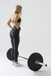 © USM Photography - Image of woman with barbell Female athlete before exercising with heavy weights at gym. Female performing deadlift exercise with weight bar