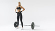 © USM Photography - Confident young blonde woman with barbell concept black and white photo Female athlete before exercising with heavy weights at gym Female performing deadlift exercise with weight bar.