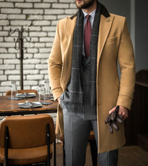 Wall Mural - Man in custom tailored suit and trench coat posing indoors