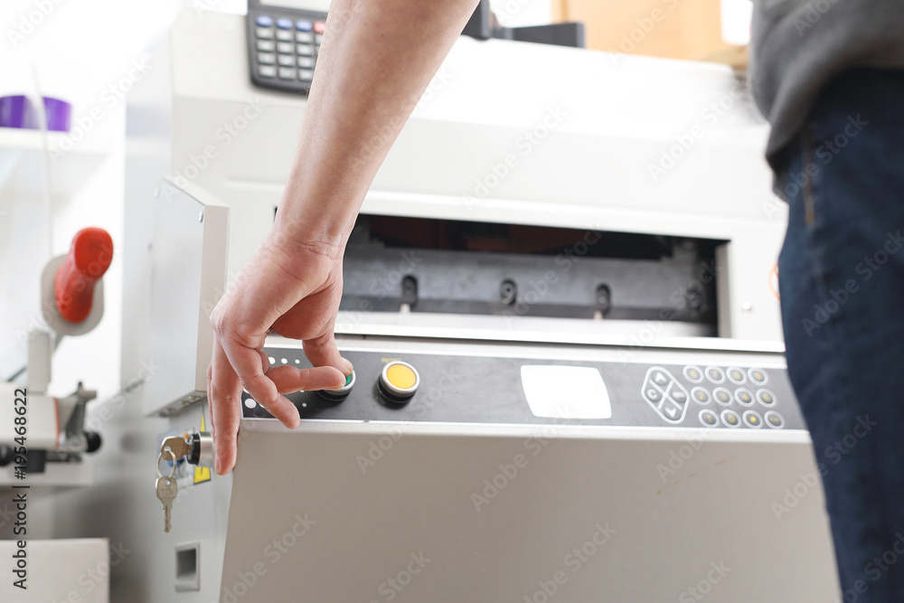 Drukarz. Pracownik obsługuje maszynę drukującą. - obrazy, fototapety, plakaty 