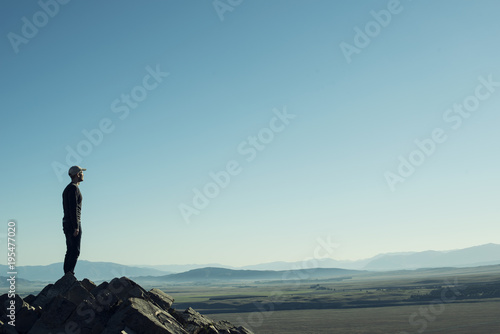 Cuadros en Lienzo Retrato de hombre a contraluz en la cima de una montaña rocosa