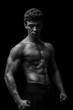 © abdulrahman - Highly retouched black and white fitness model and bodybuilder, Looking and posing abs and chest. concept of power, strength and self-confidence. black background.
