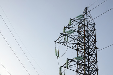 Power lines tower against the blue sky