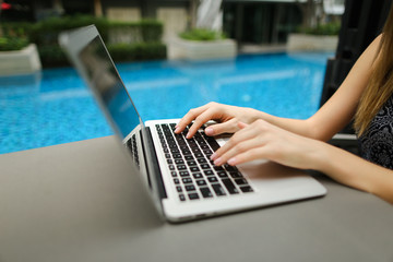 Wall Mural - fingers typing on the computer keyboard. close up portrait of woman hands pressing buttons on laptop