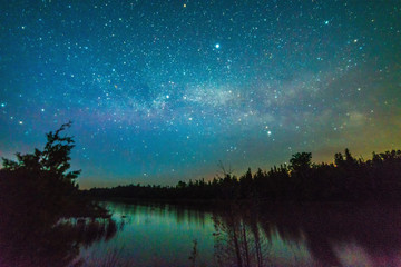 Lake reflecting with stars at night