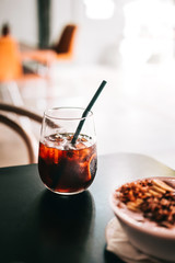 Wall Mural - Black cold brew coffee with ice cubes in a glass. Hipster coffee shop. Minimalism drink photography