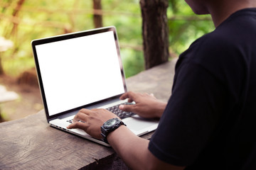 A man is working using laptop at park / outdoor, blank screen for background
