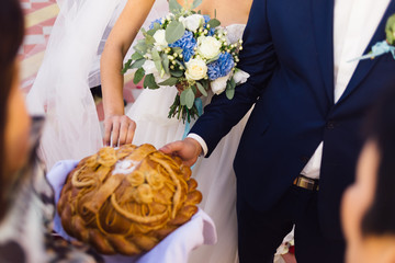 The bride and groom break a piece of wedding bread