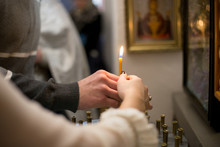 Hands Holding A Candle In The Temple