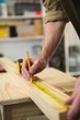 © Wavebreak Media - Male carpenter measuring and marking wood in workshop