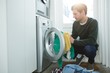 © Wavebreak Media - Man putting clothes in washing machine