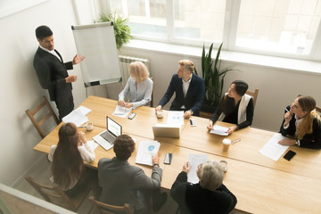 Poster - African american ceo boss in suit giving presentation at corporate team meeting concept, diverse executive group listening to black speaker explaining new plan coaching employees in conference room