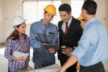 Businessman working with Architect Engineer on laptop computer in building Construction Site with blueprint.