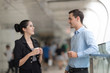 © Nattanon - Two colleagues walking in street of city talking to each other while holding disposable coffee cups.
