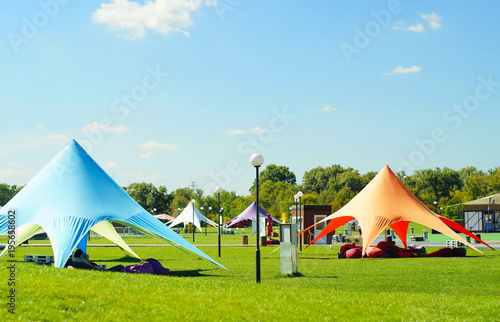 A white tent or marquee in a green field.  Tent awning Star, star tent, outdoor activities, events, beautiful awning for relaxation
