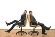 © realstock1 - The two happy men sit on chairs on the white wall background
