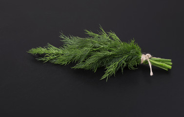 Sticker - A bunch of fresh dill tied with a rope on a black background