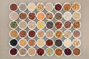 Wall Mural - Vegan high protein dried super food selection with nuts, seeds, legumes, cereals and grains. Health foods high in fibre, antioxidants, anthocyanins, minerals and vitamins. On hessian, top view.