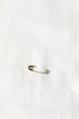 © Kelly Knox/Stocksy - small safety pin attached to white fabric