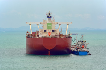 Wall Mural - Loading anchored oil supertanker via a ship-to-ship oil transfer (STS) from raid tanker