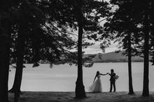 Black And White Portrait Of A Bride And Groom Dancing By A Lake