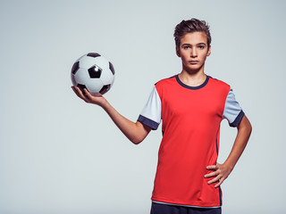 Wall Mural - Photo of teen boy in sportswear holding soccer ball