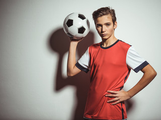 Wall Mural - Photo of teen boy in sportswear holding soccer ball