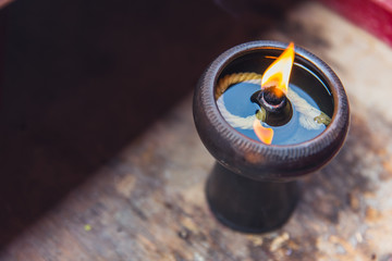 Ancient oil lamp made in clay on wood table