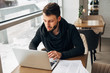 © newagecinema - bearded hipster working at a laptop in a cafe
