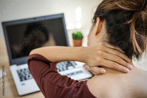 Fotomural Young woman working at home and having neck pain